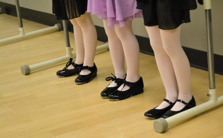 三个舞者的脚穿着踢踏舞鞋