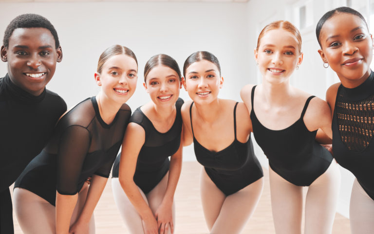 一群年轻的芭蕾舞演员对着镜头微笑